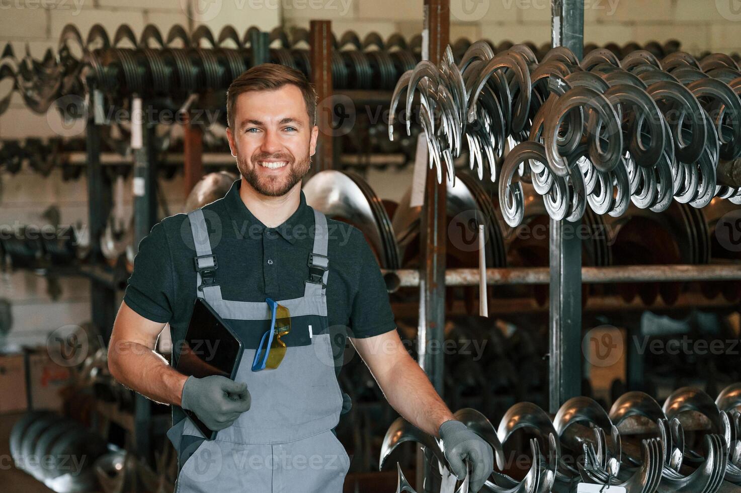 Grey uniform. Man is in workstation developing details of agriculture technique photo