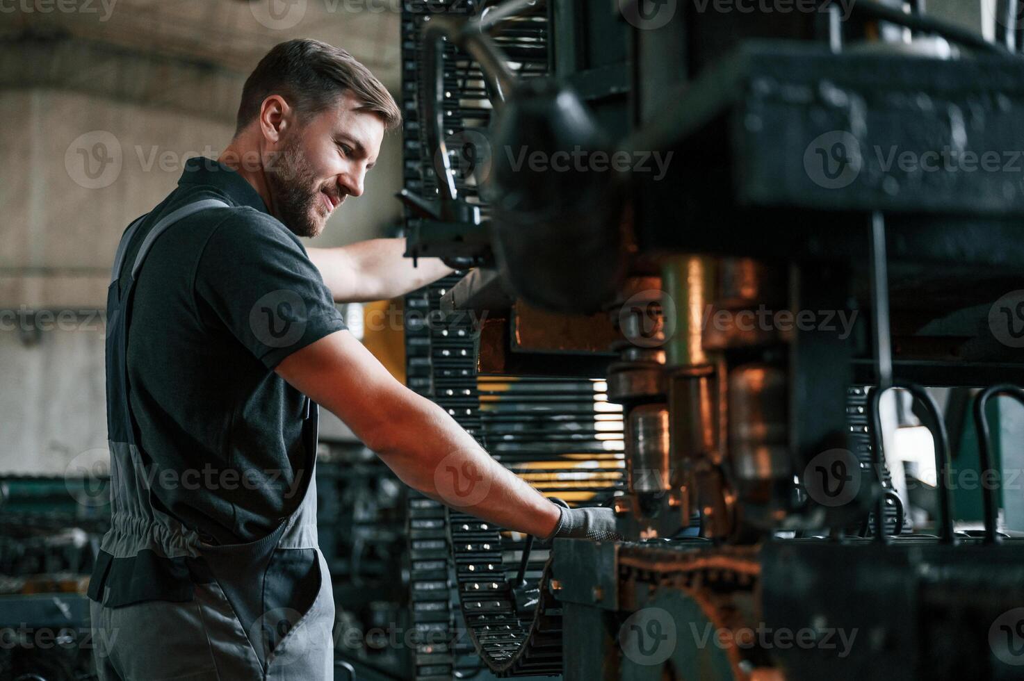 Metal processing device. Man in uniform is in workstation developing details of agriculture technique photo