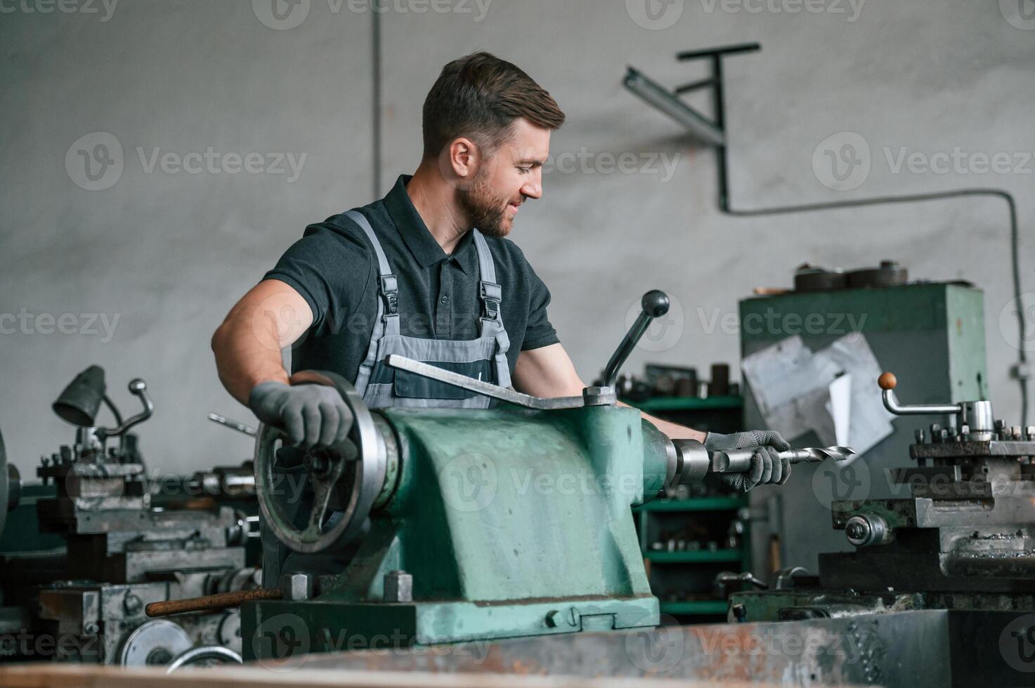 Turning wheel. Man in uniform is in workstation developing details of agriculture technique photo