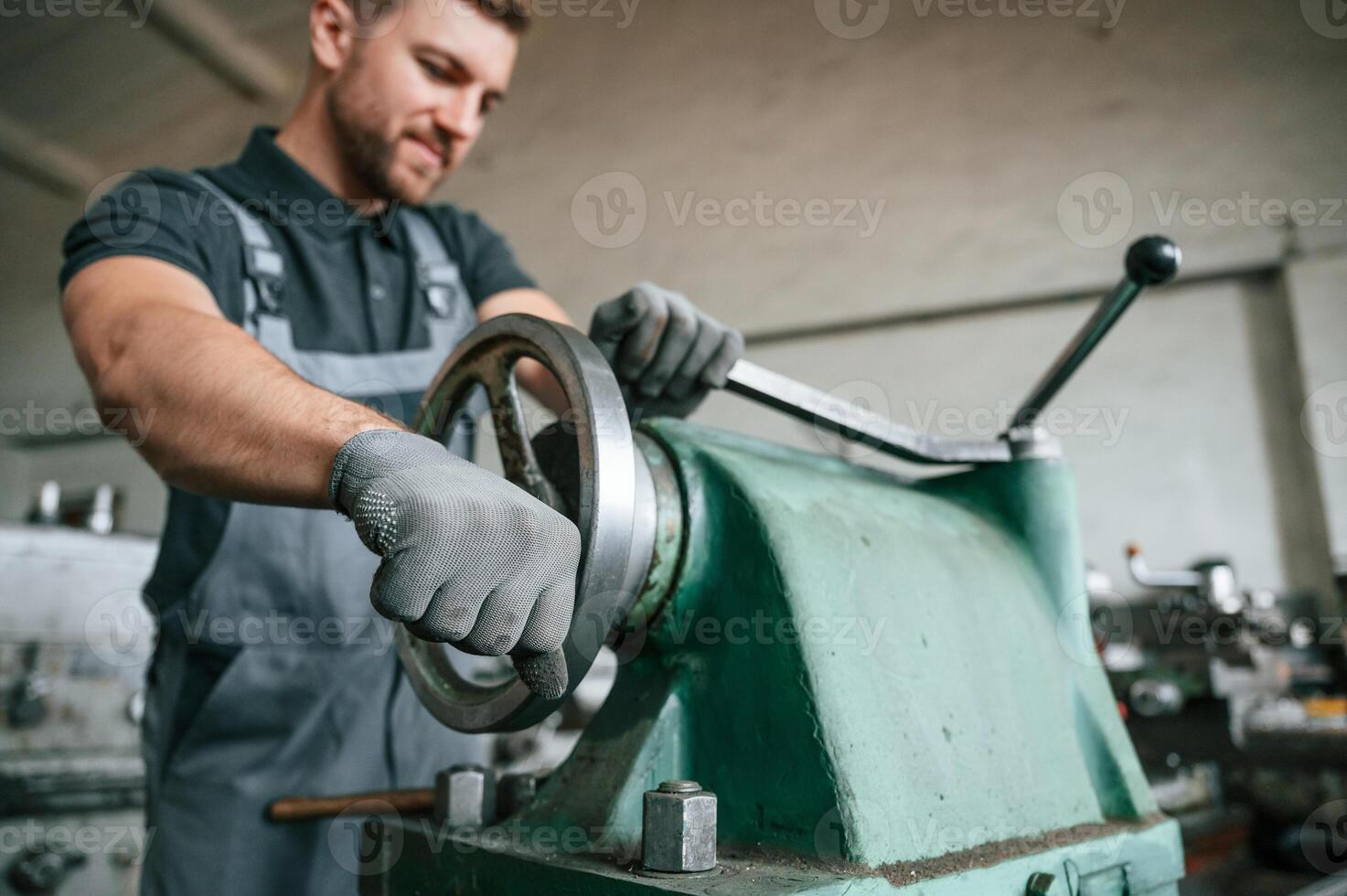 Turning wheel. Man in uniform is in workstation developing details of agriculture technique.. photo