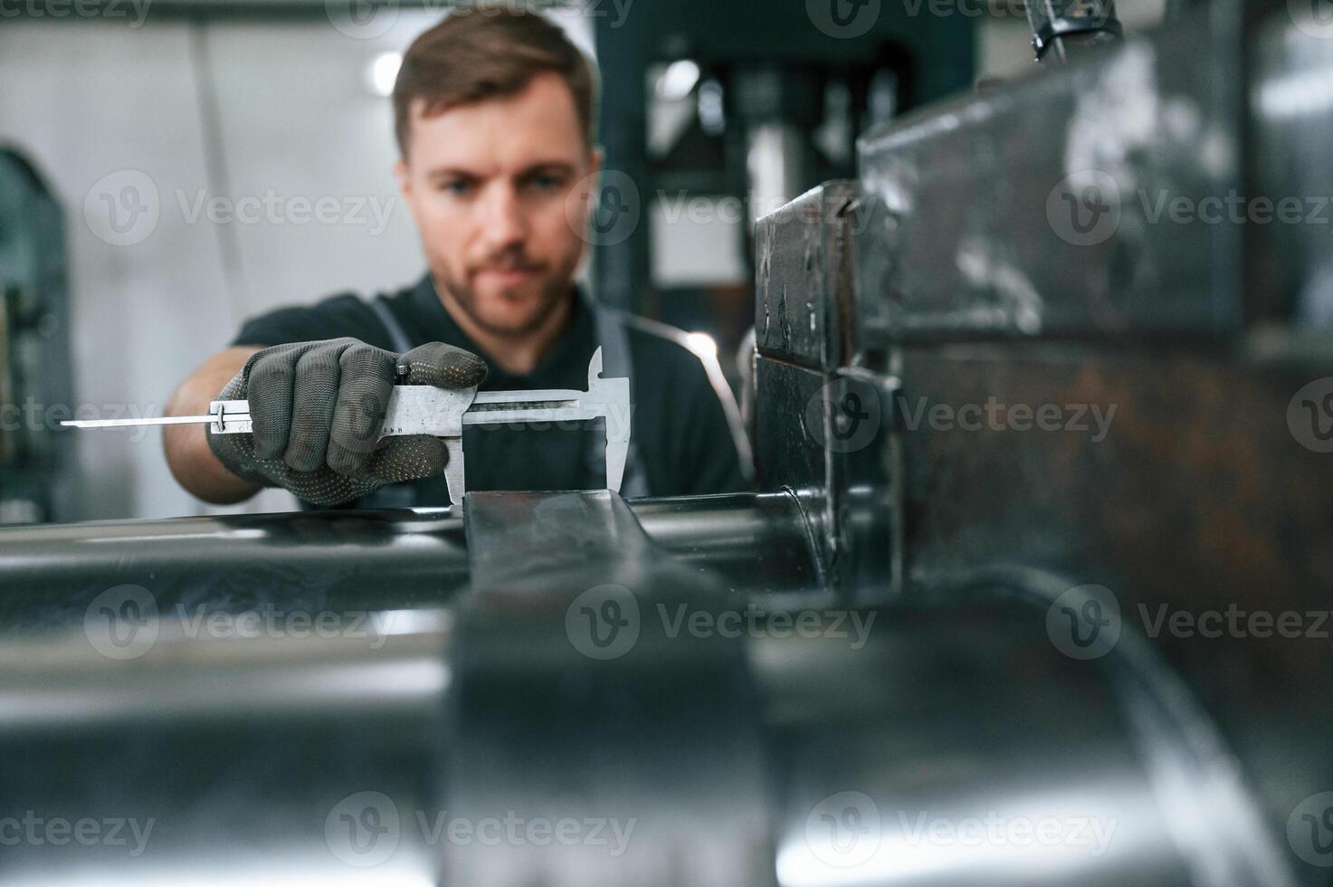 Using measure tool. Man in uniform is in workstation developing details of agriculture technique photo