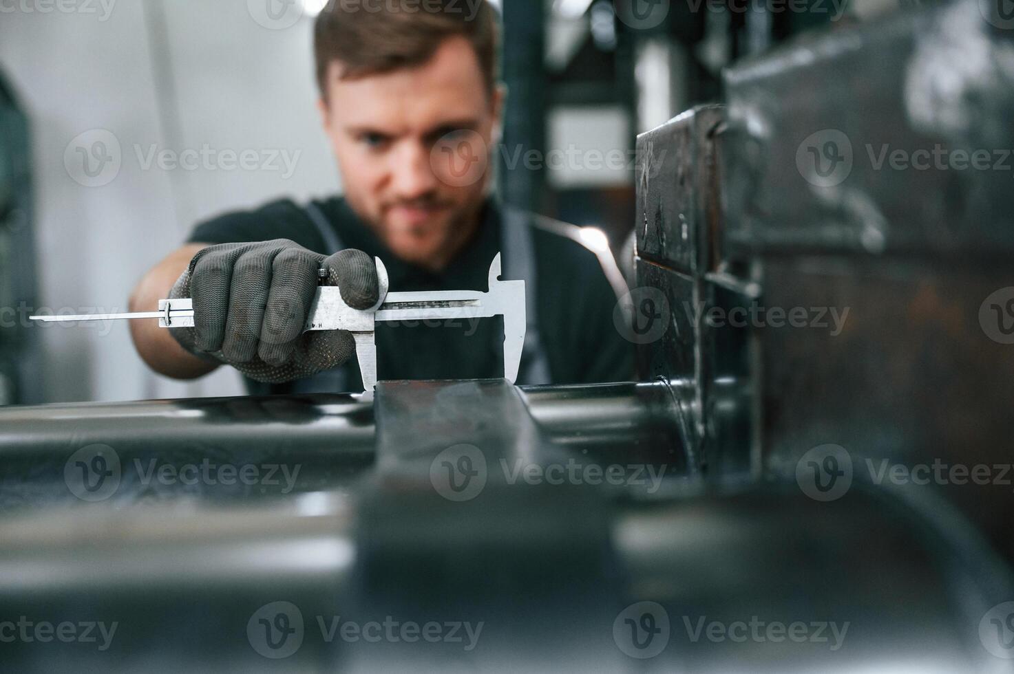 Using measure tool... Man in uniform is in workstation developing details of agriculture technique photo