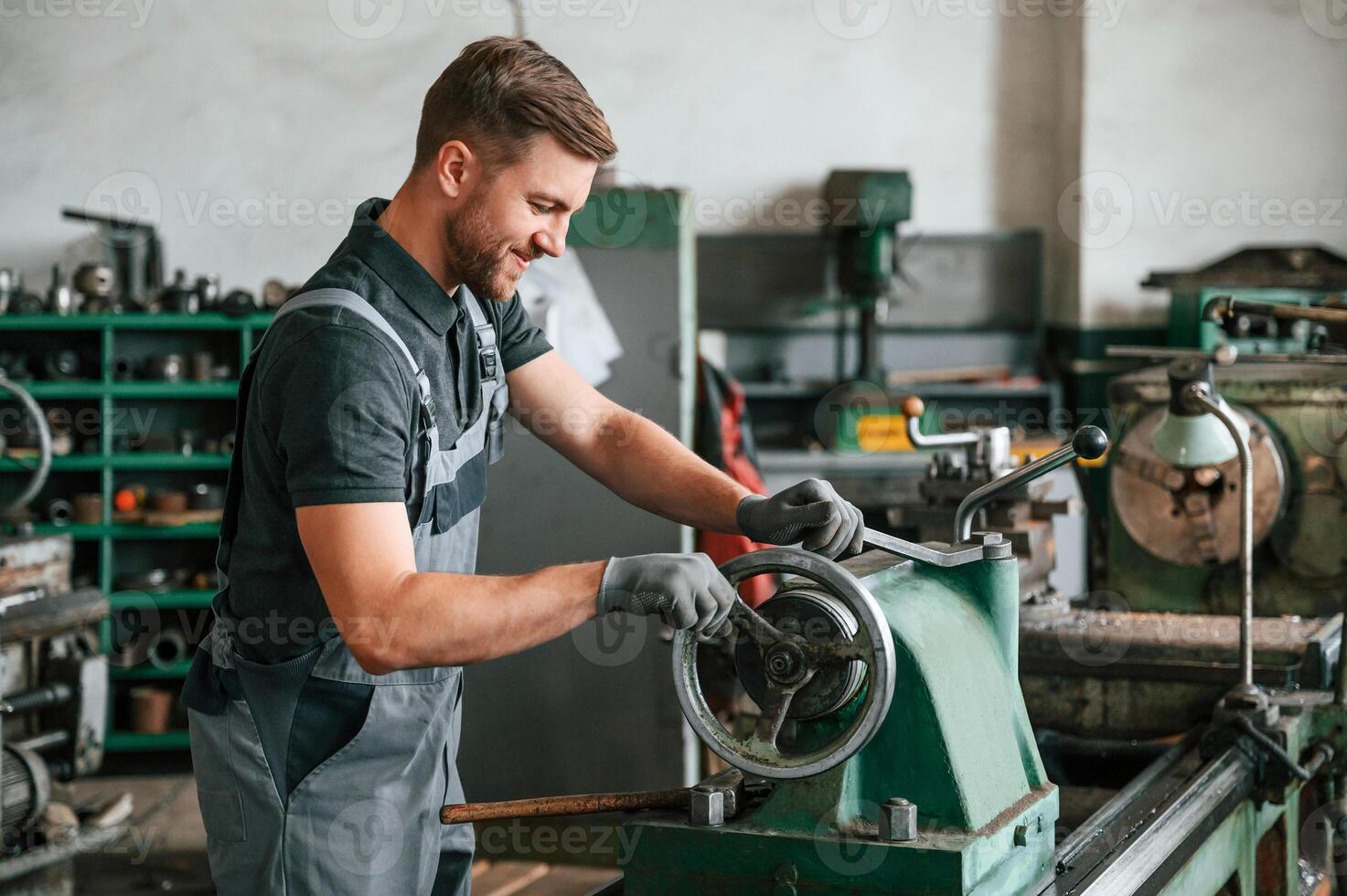 Turning wheel.. Man in uniform, is in workstation developing details of agriculture technique photo