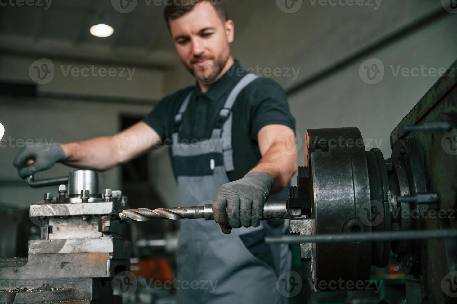 Crafting details. Man in uniform is in workstation developing details of agriculture technique.. photo