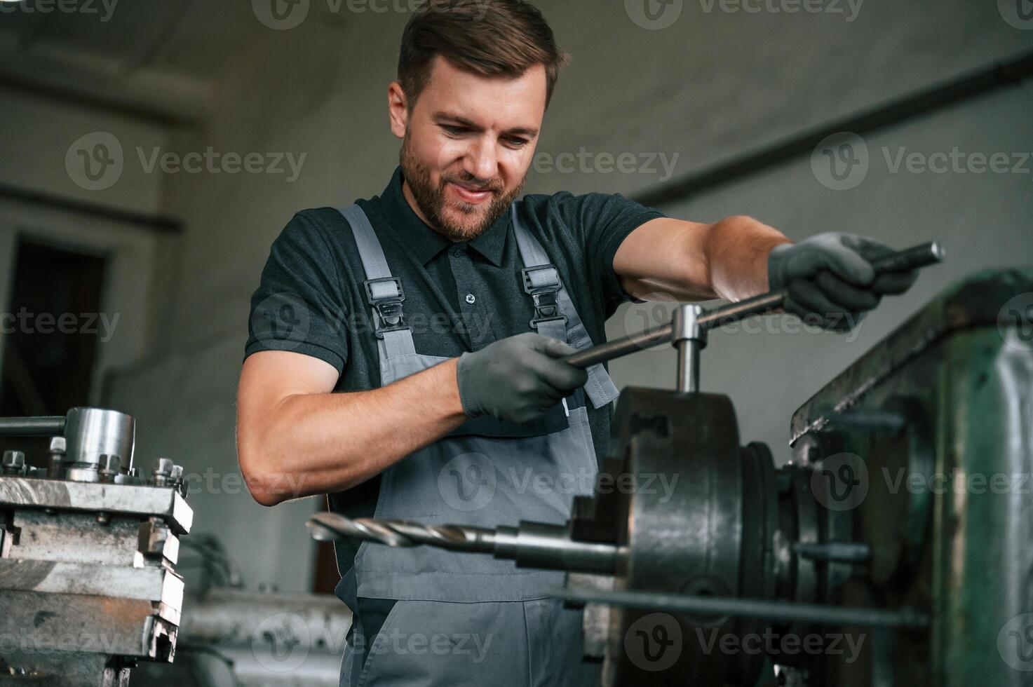 With the mount in drill. Man in uniform is in workstation developing details of agriculture technique photo