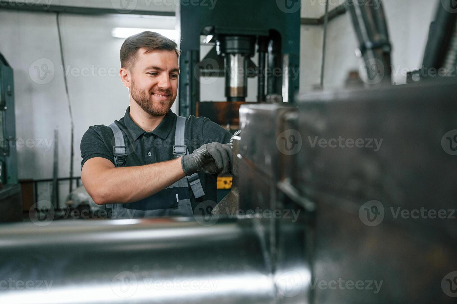 Professional engineer operating machine. Man in uniform is in workstation developing details of agriculture technique photo