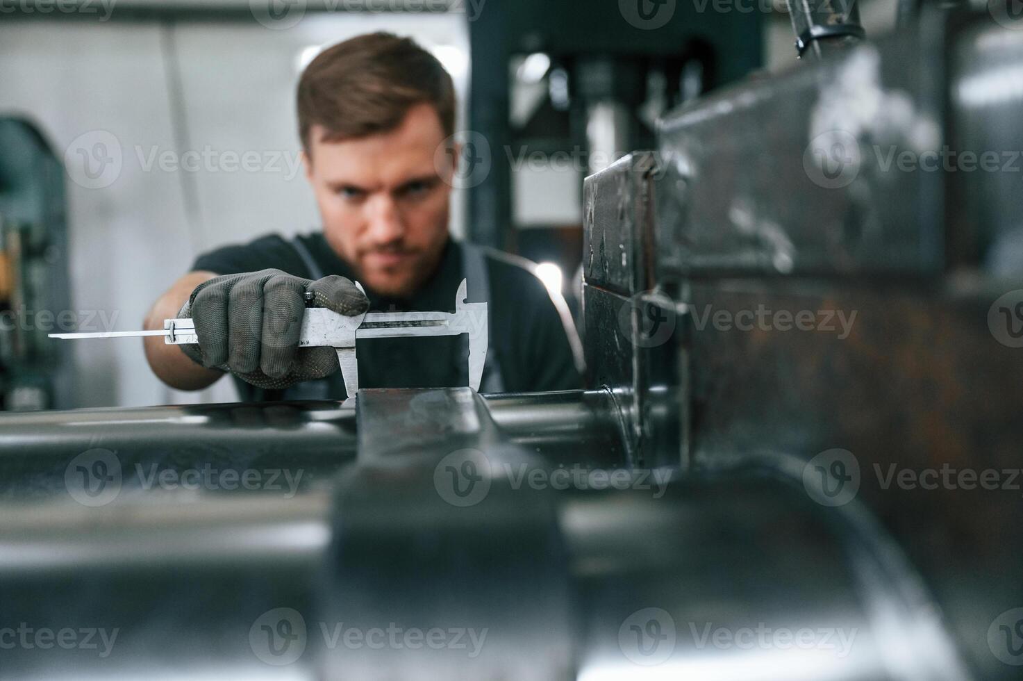 Using measure tool. Man in uniform is in workstation develop,ing details of agriculture technique photo