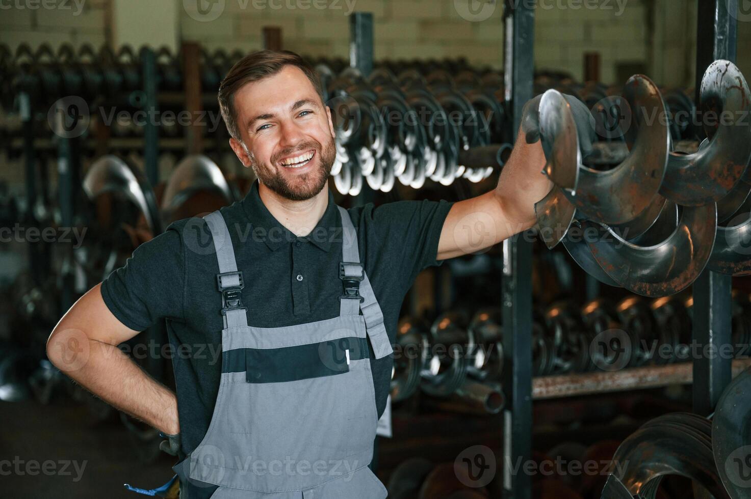 Man, in uniform is in workstation developing details of agriculture technique photo