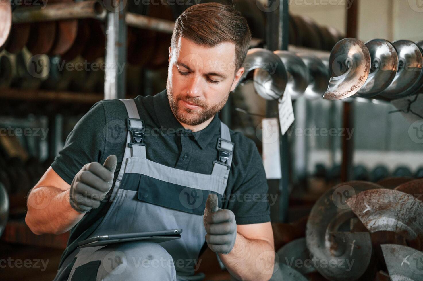 Manager, is using digital tablet.. Man in uniform is in workstation developing details of agriculture technique photo