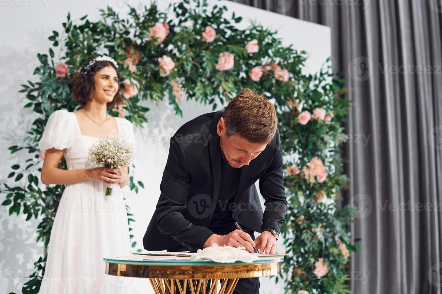 Signs the marriage document.. Beautiful bride with his fiance is on the wedding photo