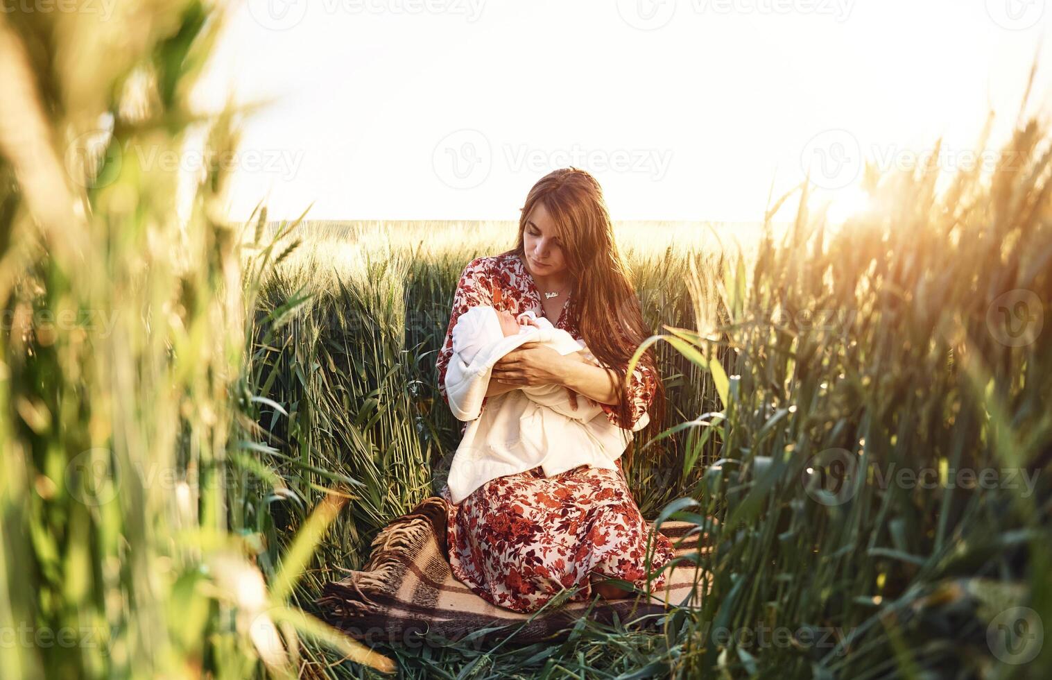 Conception of parenting. Gorgeous woman is on the agricultural field with her newborn baby photo