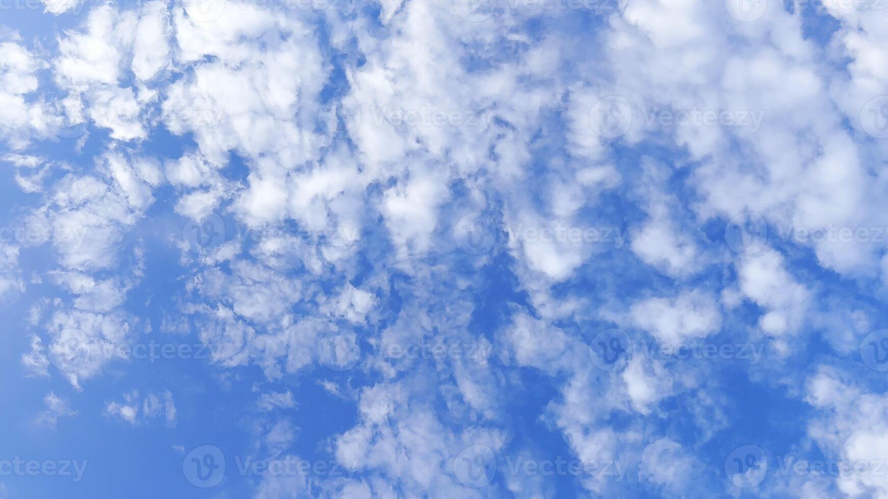 Camera move behind white fluffy clouds on blue sky at summer sunny day. Beautiful nature background. Close up Slow motion photo