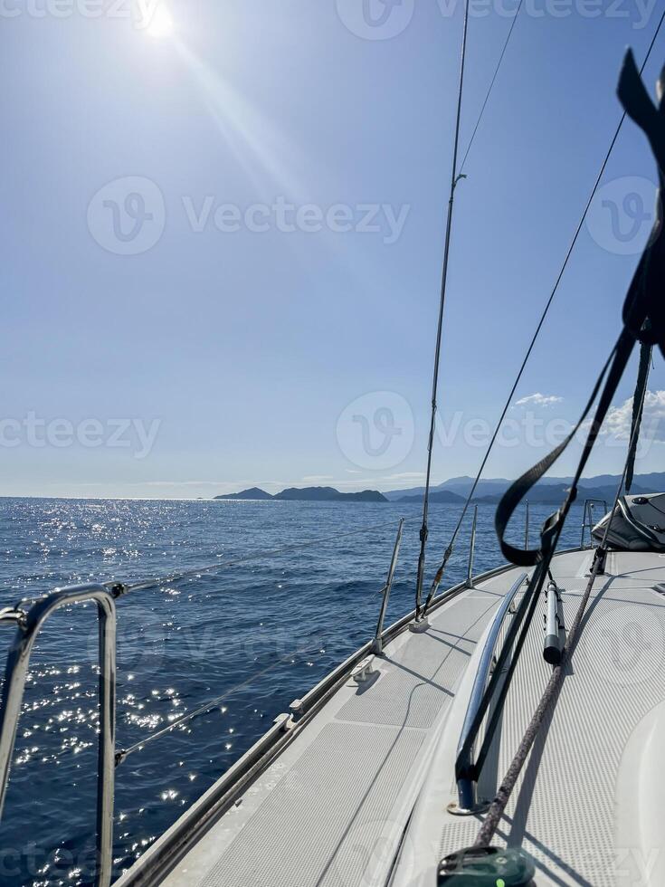 Sailing on a clear day with calm waters near distant islands in the horizon photo
