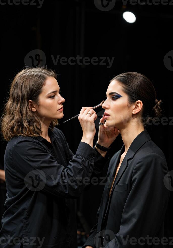 Makeup artist applying make up to a model in the studio. Makeup Artist at Work photo