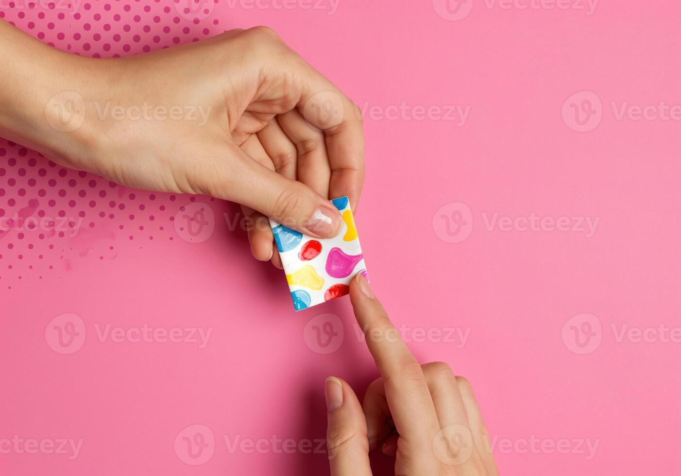 Female hands holding colorful peel off nail mask on pink background. Top view. Colorful Peel Off Nail Mask photo