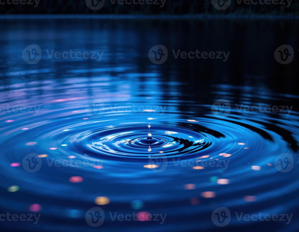 Water drop on the surface of the water with ripples and reflection. Water Droplet Ripple photo