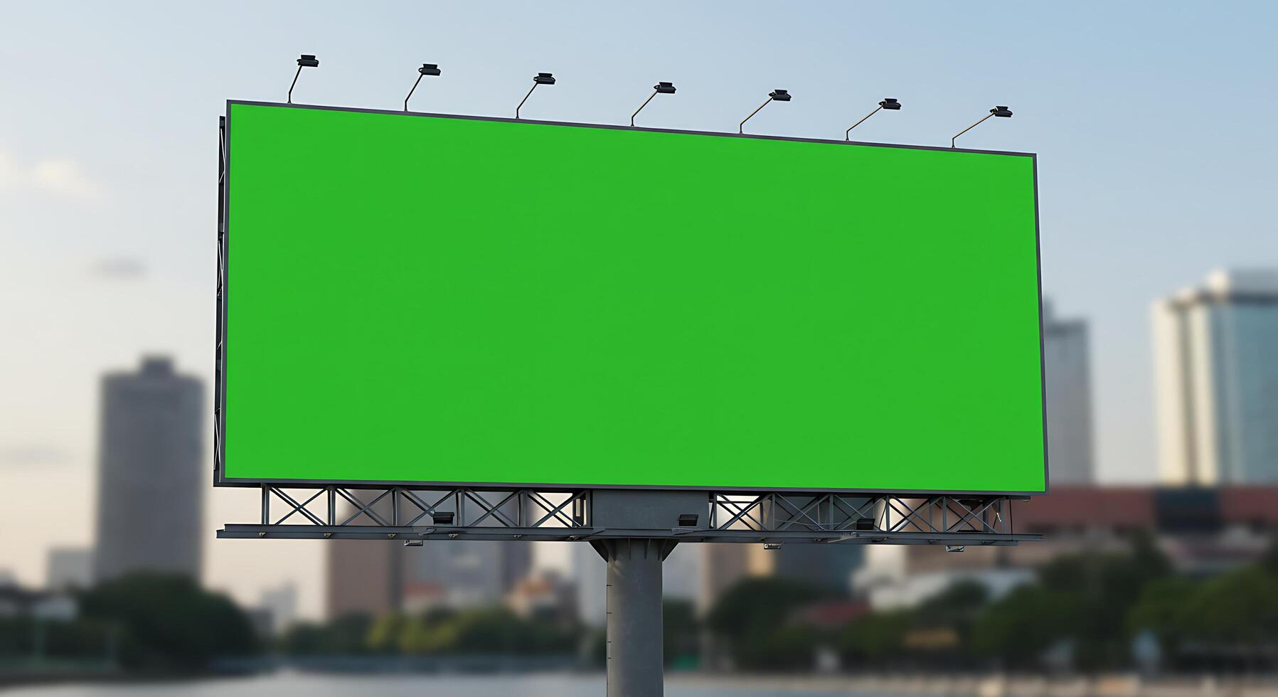 A green billboard on a street with a city in the background photo