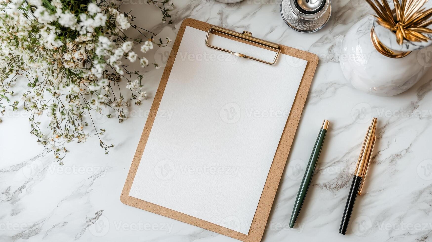 Blank clipboard on marble table with flowers and vases photo