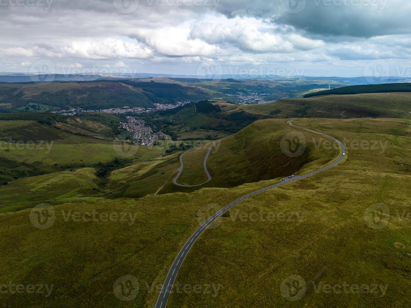 Winding road leading through green meadows in the welsh countryside photo