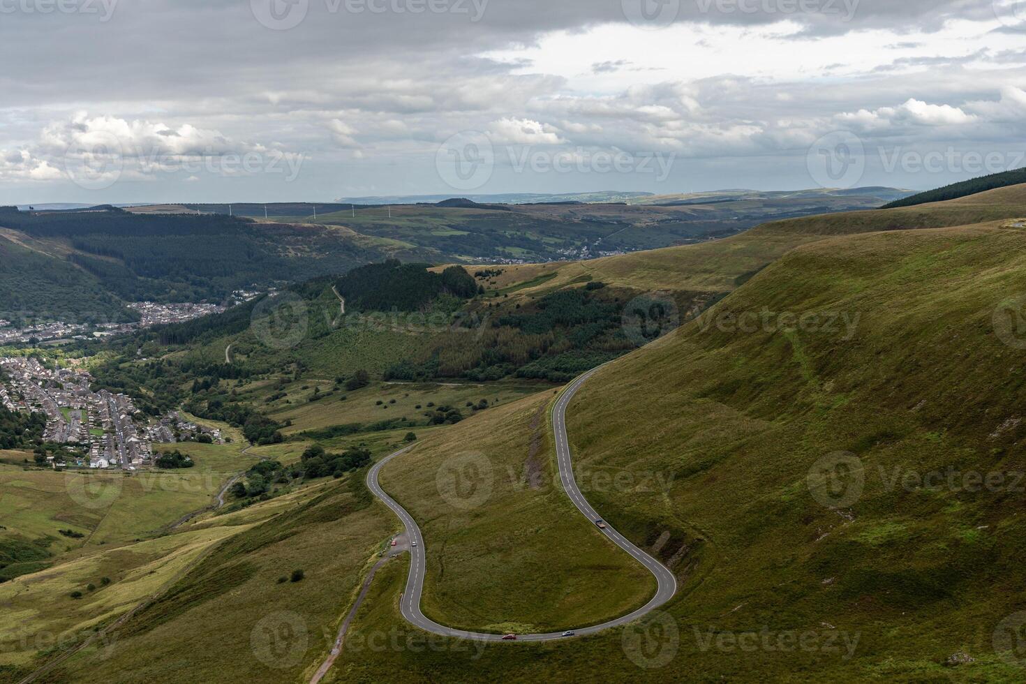 Winding road leading to small town in wales countryside photo
