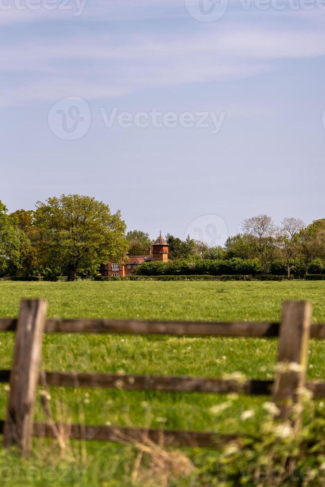 Idyllic country house viewed over rustic fence photo