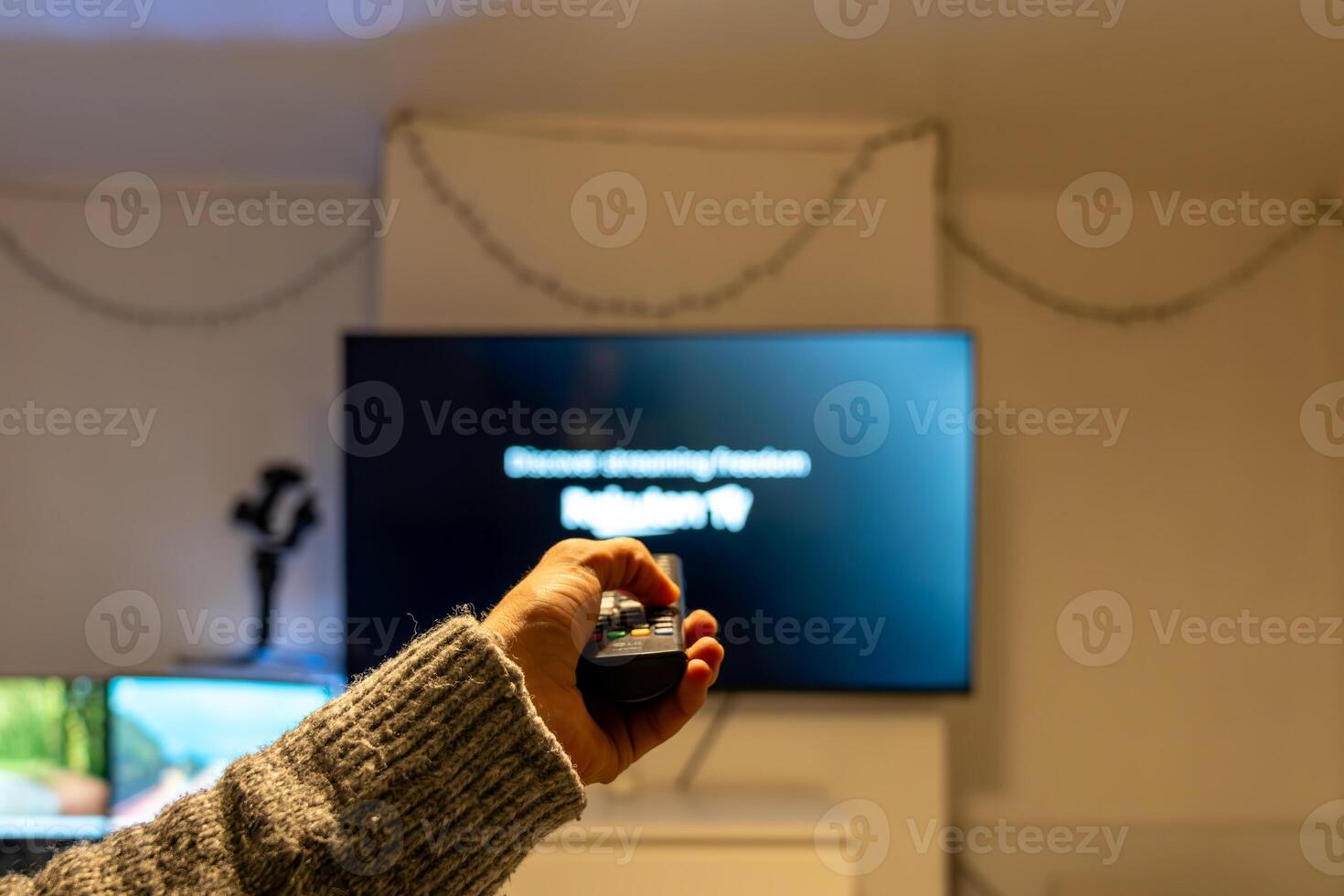Man using remote control, watching television at home photo