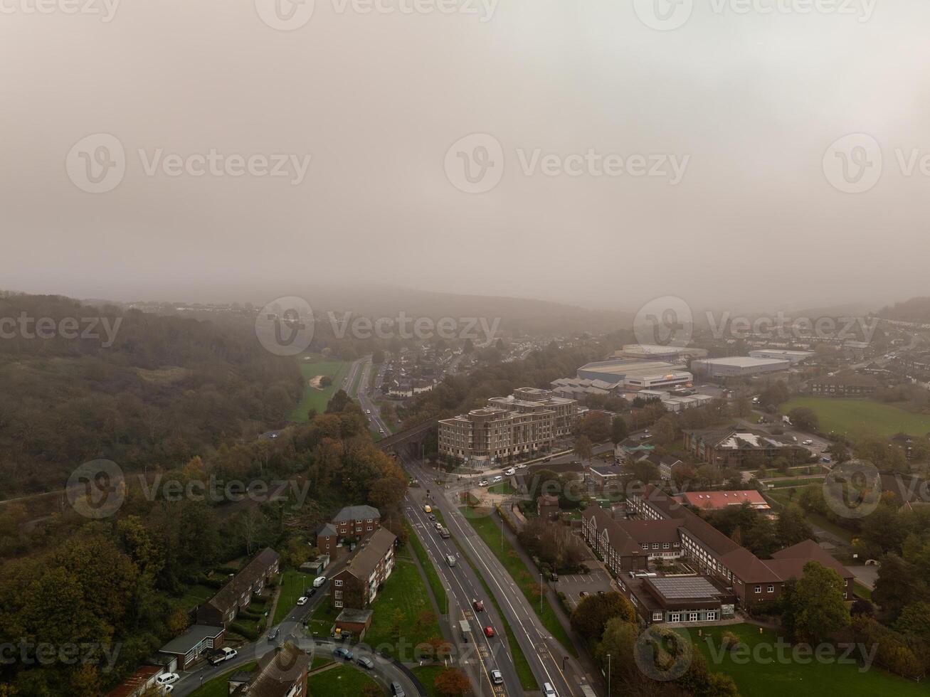 Fog covering residential neighborhood with road and trees in autumn photo