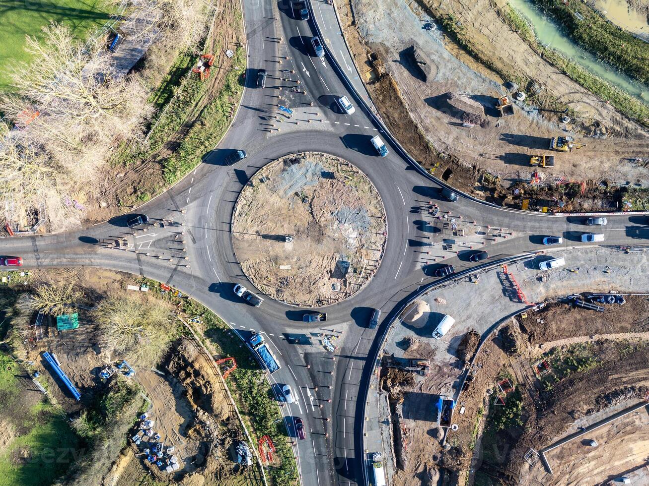 Cars driving on roundabout under construction, aerial view of road work photo