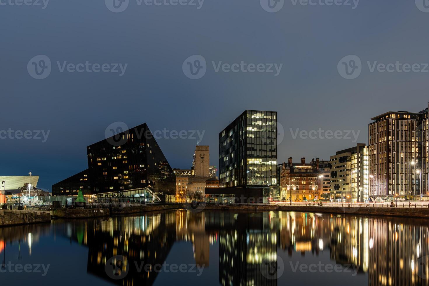 The modern buildings of liverpool are reflecting in the water of the docks photo