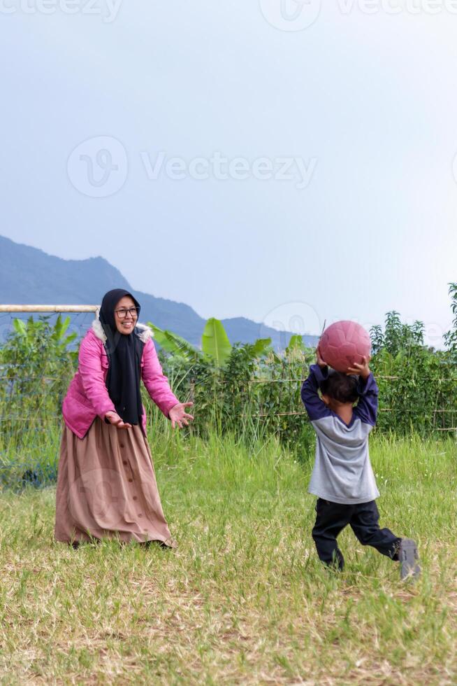 Mother and Son Playing Ball in a Rural Field photo