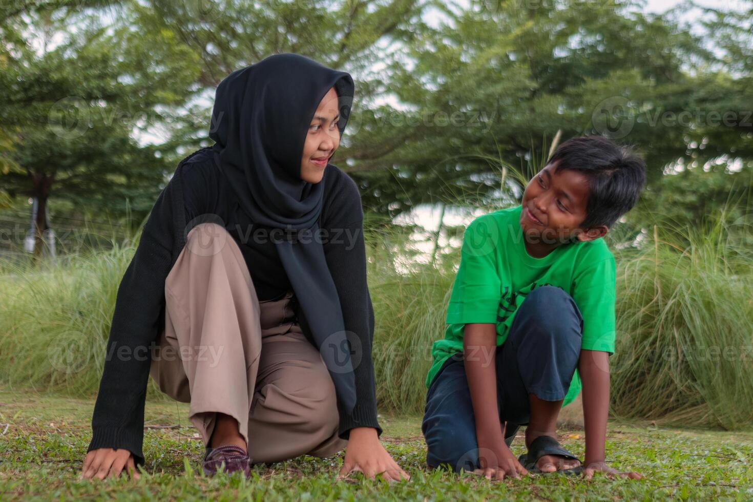 Muslim Woman and Boy Smiling Together Outdoors in a Park photo