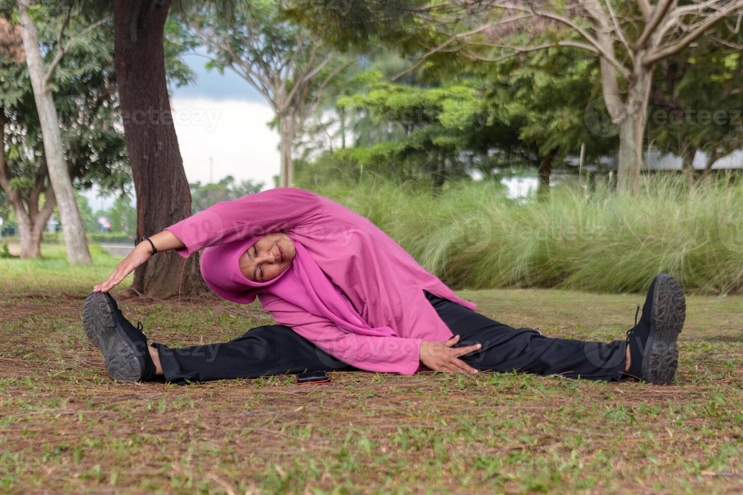Muslim Woman Doing Side Stretching Exercise in Outdoor Park photo