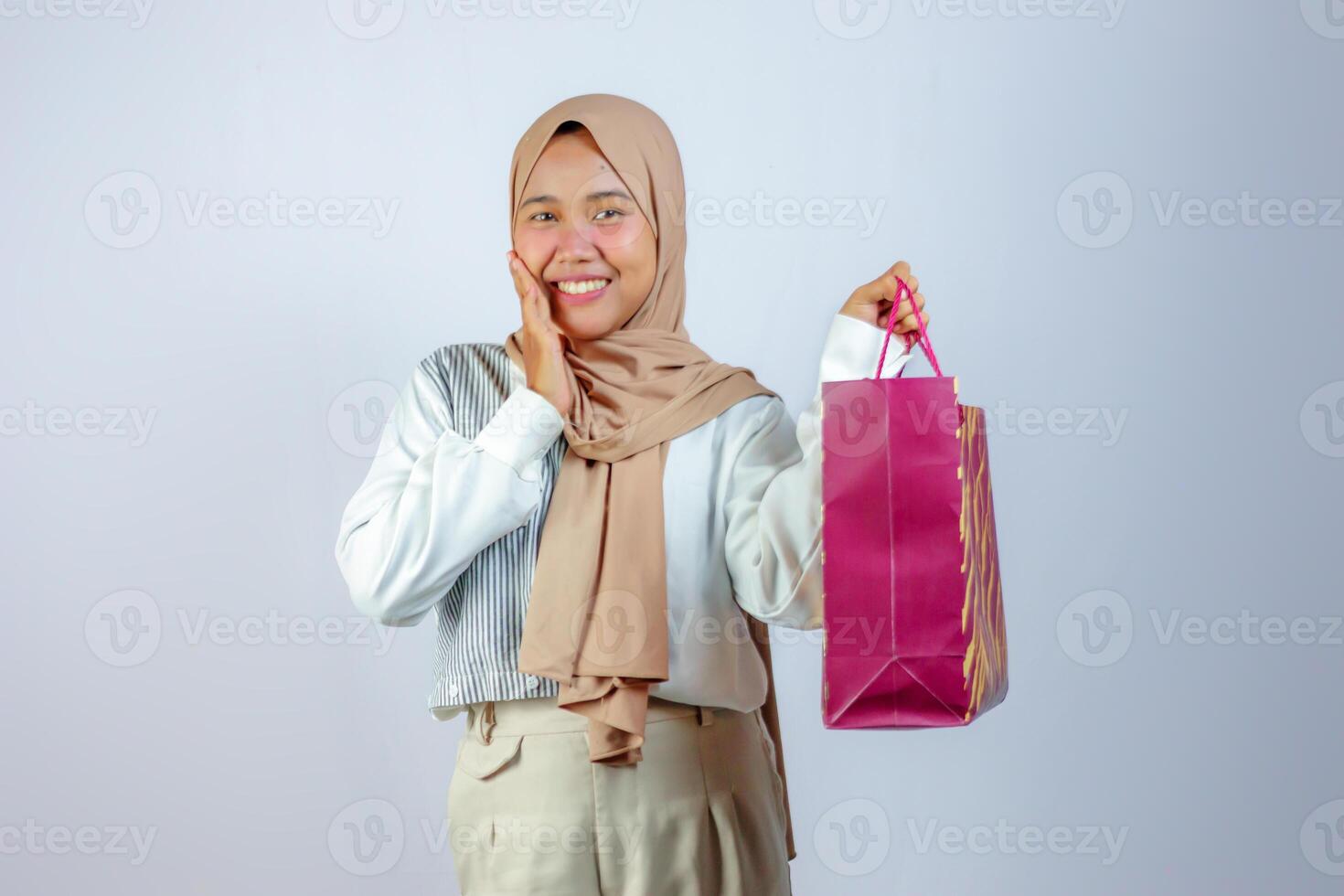 Happy Muslim Woman Holding Shopping Bag with Excitement photo