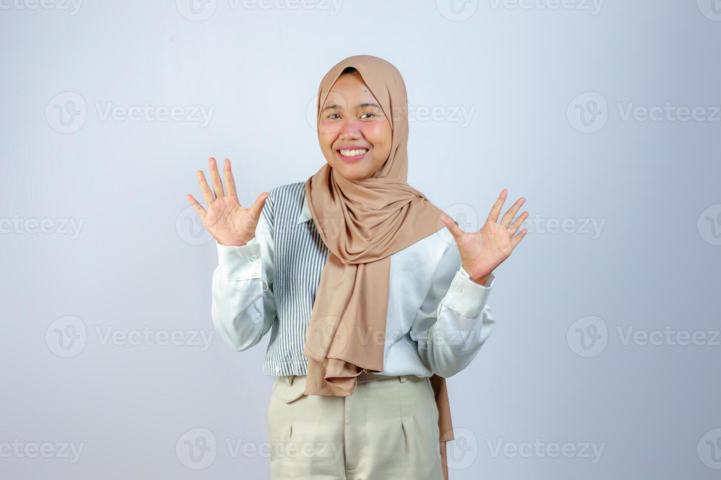 Cheerful Muslim Woman in Hijab Showing Open Hands in a Friendly Pose photo