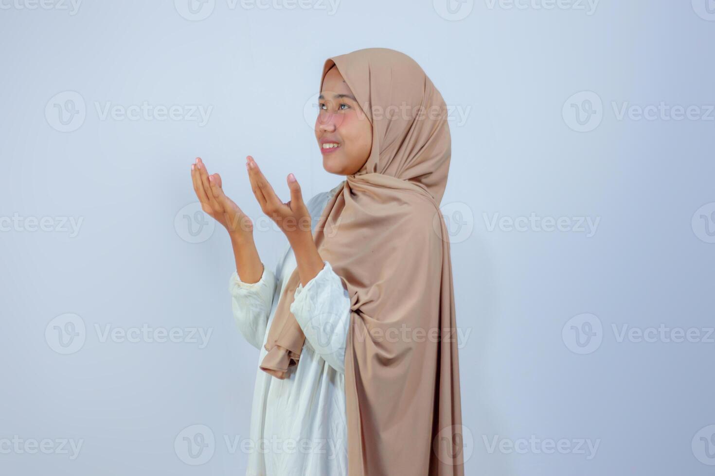 Smiling Muslim Woman in Hijab Praying with Open Hands photo