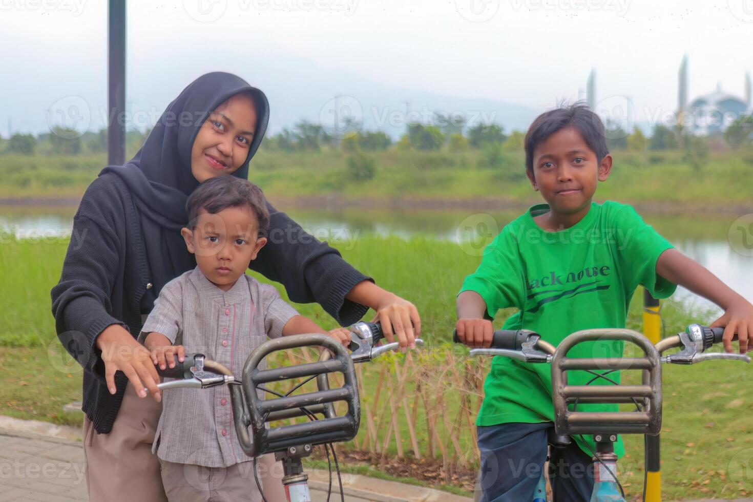 Muslim Sister and Brothers Enjoying Bicycle Ride in Park photo