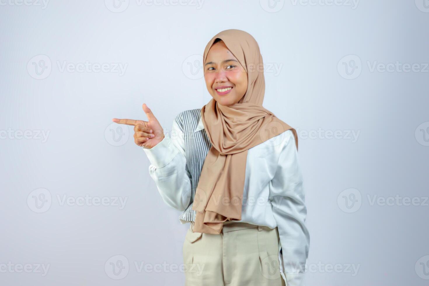 Cheerful Muslim Woman in Hijab Pointing with a Confident Smile photo