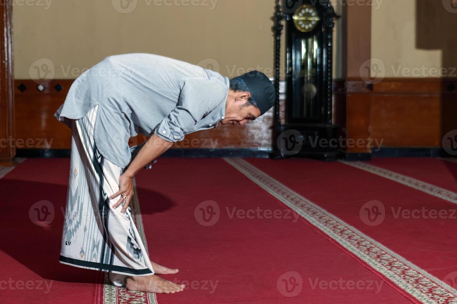 Muslim Man Bowing in Prayer at Mosque on Eid Mubarak Worship Moment photo