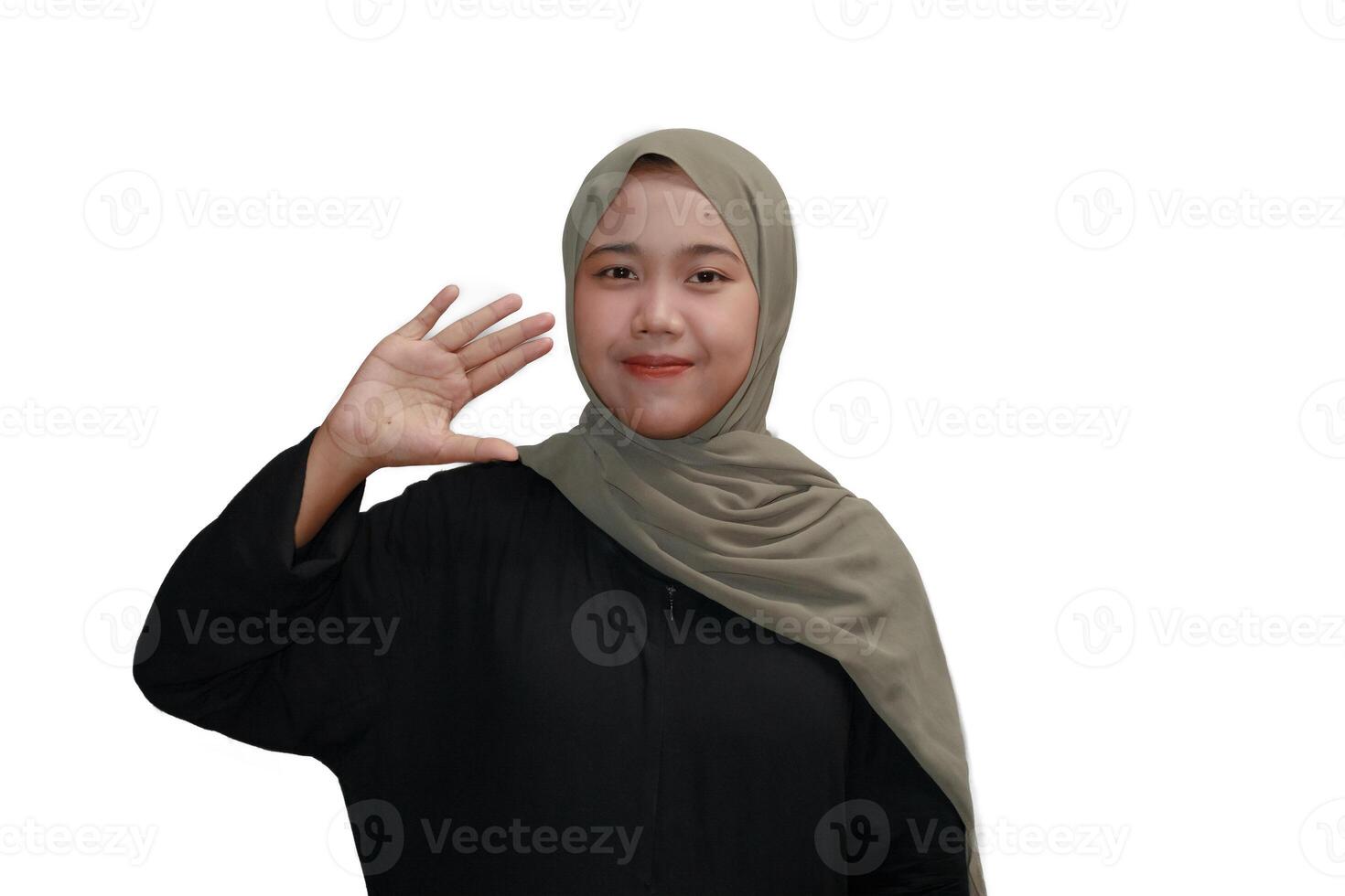 Smiling Muslim Woman in Hijab Making a Friendly Hand Gesture photo