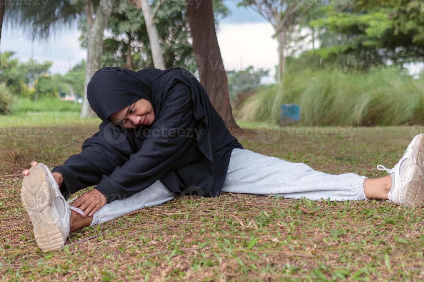 Muslim Woman Stretching in Outdoor Park for Healthy Lifestyle photo