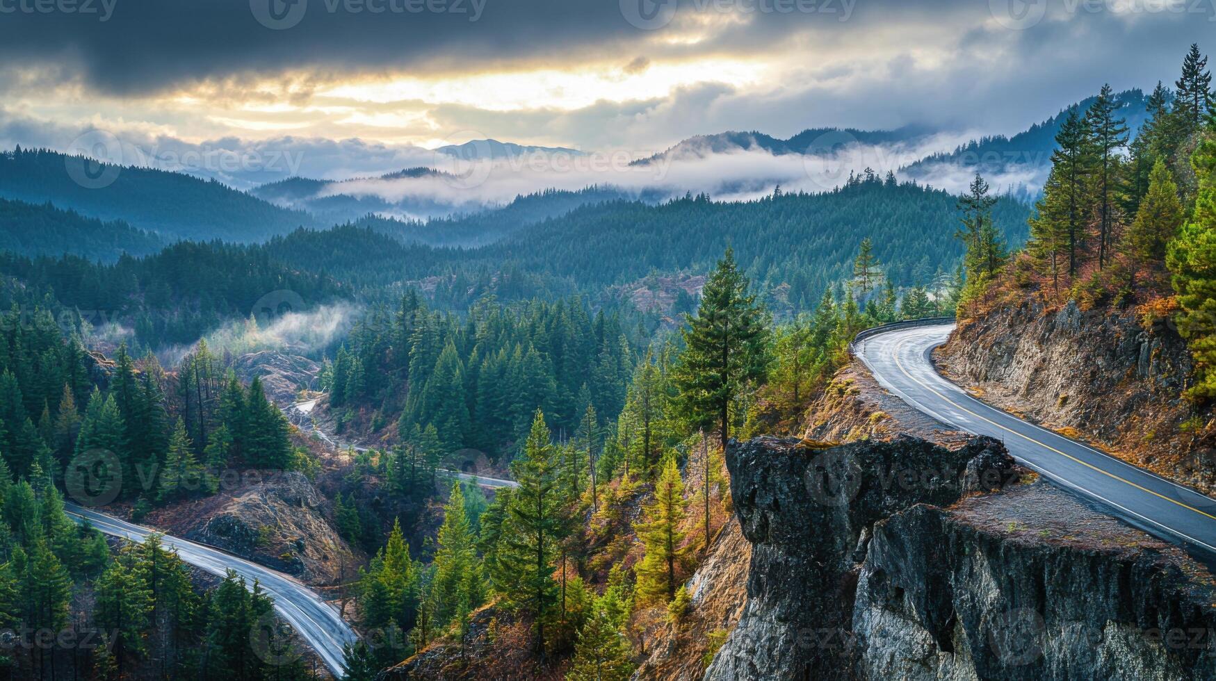 A mountain range with a winding road that leads to a cliff photo