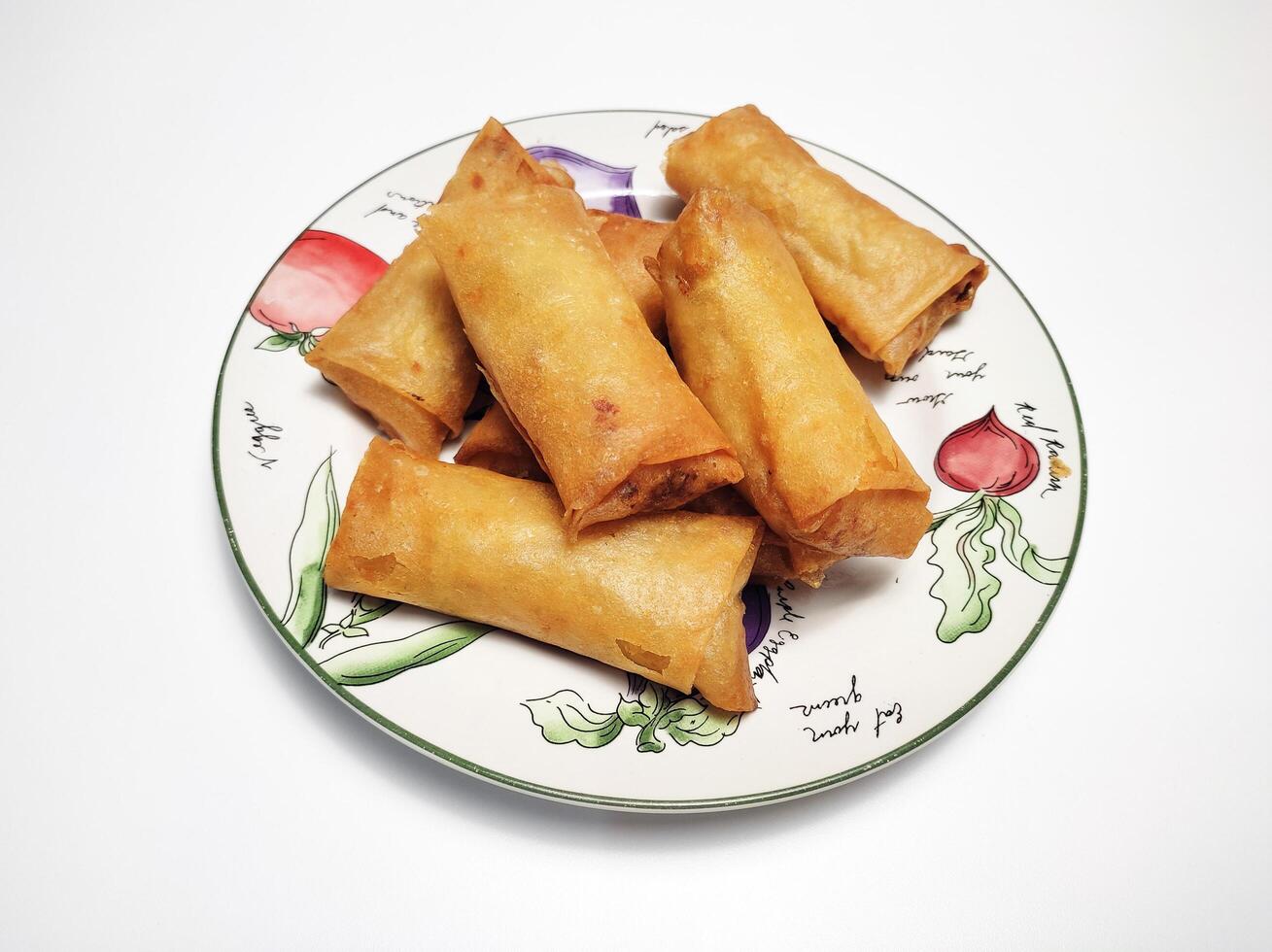 Fried spring rolls or lumpia, typical Indonesian snack, on a patterned plate, isolated in white background 1 photo