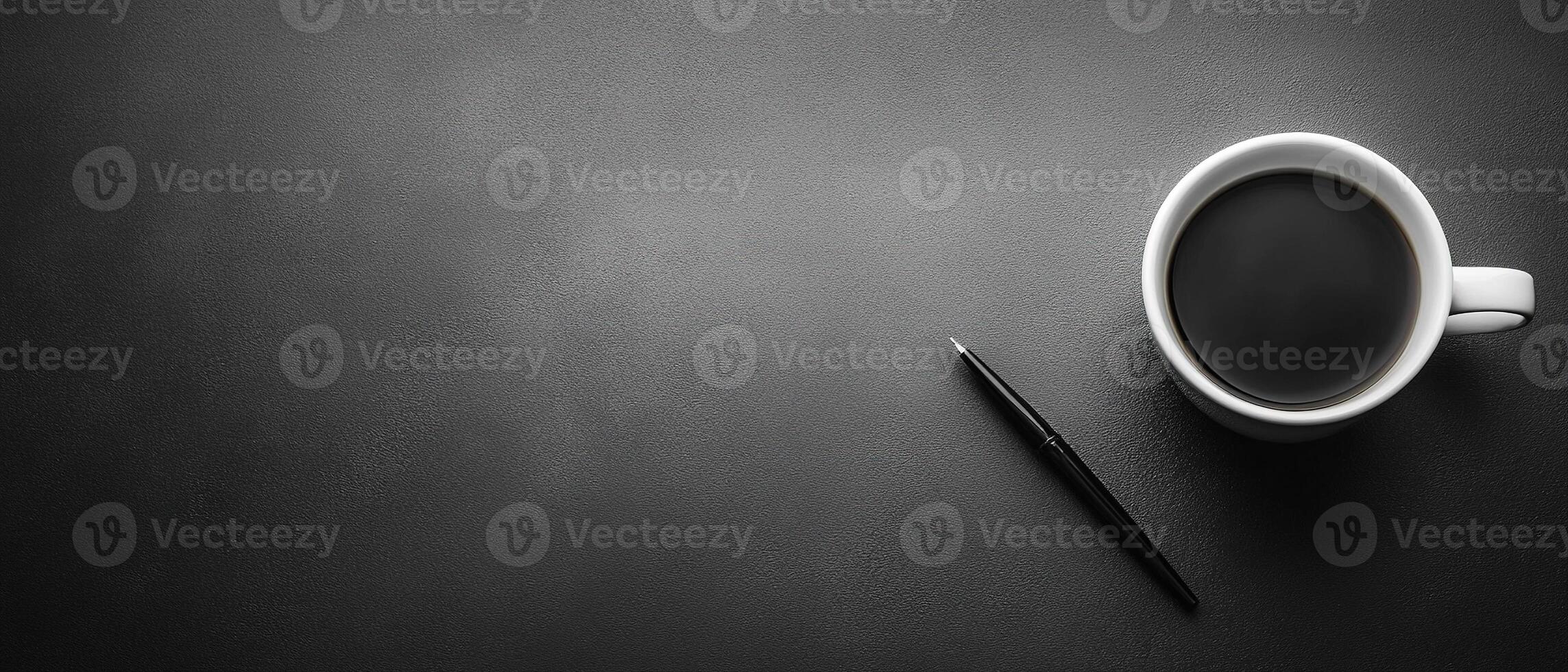 Top View of a White Coffee Cup and Black Pen on a Dark Textured Desk with Copy Space photo