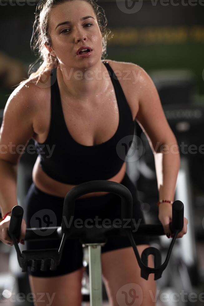 A focused fitness woman performing a conditioning workout in the gym, pushing her limits with strength, determination, and intense dedication. photo