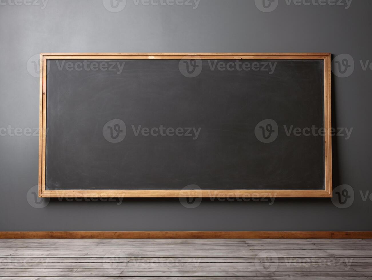 A large blackboard sits against a gray wall. The board is empty, with no writing on it. The room is bare and empty, with no furniture or decorations photo