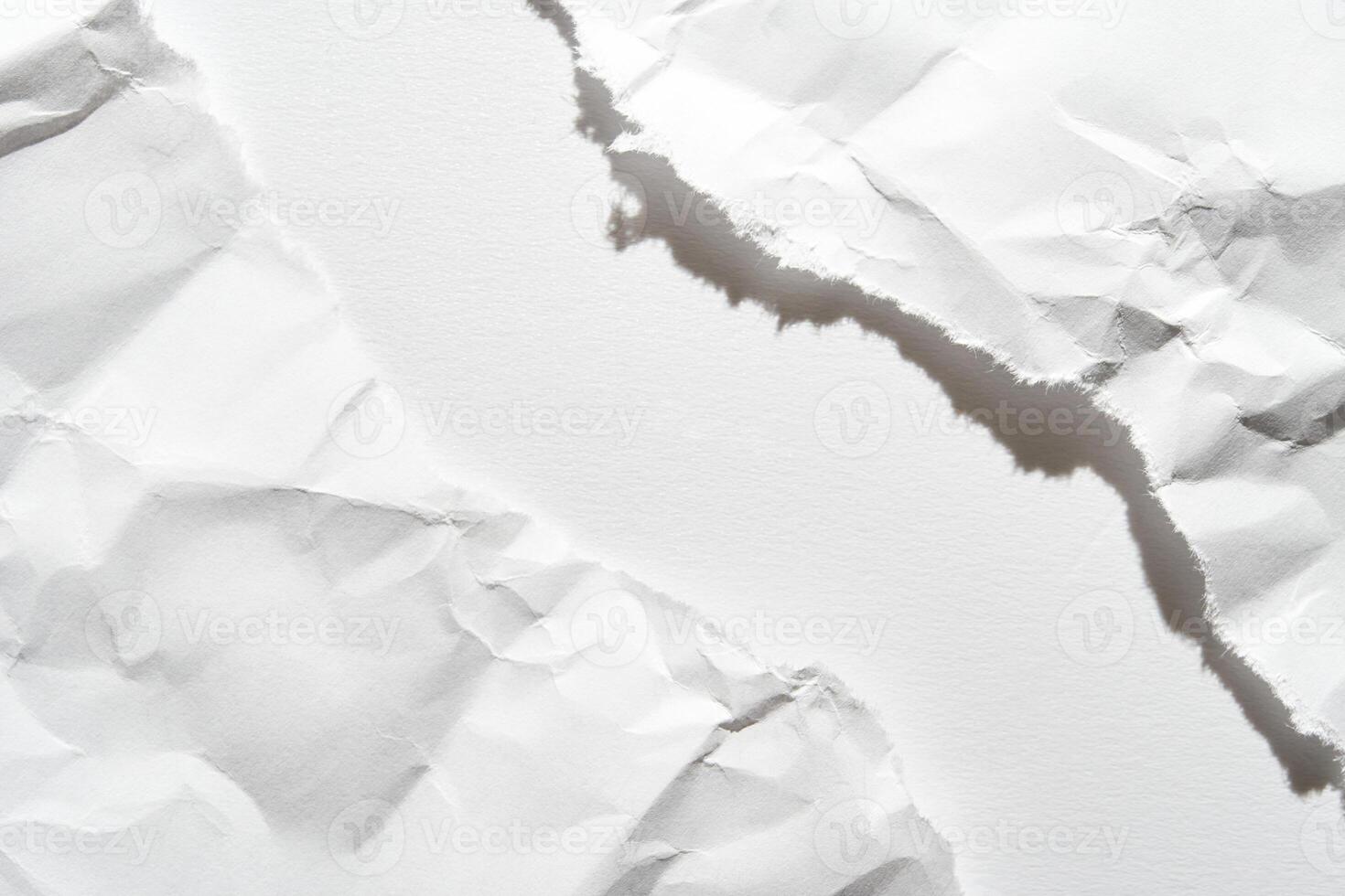 Close-up of torn white paper with rough edges and textured surface creating abstract composition. photo
