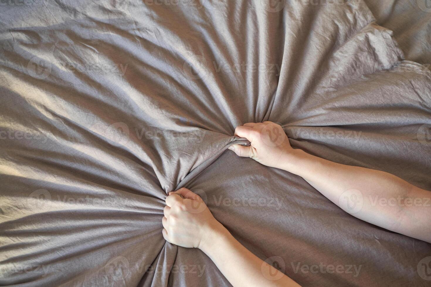 Close up of caucasian female hands gripping beige fabric with force and texture. photo