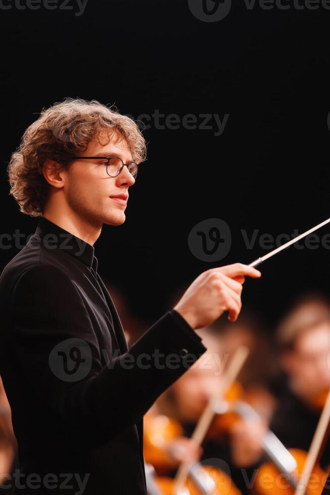 Young Conductor Leading an Orchestra with Passion and Precision photo