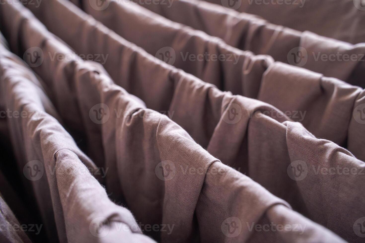 Close up of brown fabric folds with textured surface and soft creases in natural light. photo