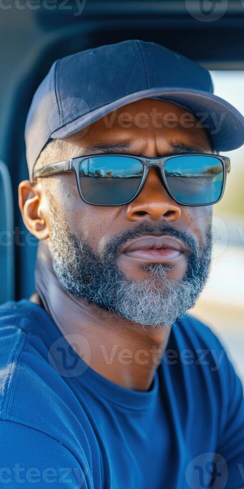 Confident Mature Man in Sunglasses and Cap with a Relaxed Expression Outdoors photo